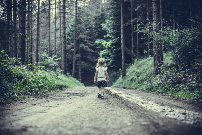 Little girl walking down a path in the forest